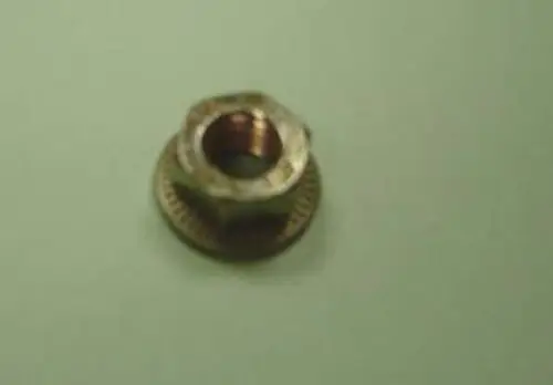Mutter in metallischer Ausführung, die aus mehreren Teilen besteht. Sie könnte Bestandteil eines Remeha-Produkts sein, ist jedoch alleinstehend auf einem hellen Hintergrund abgebildet.